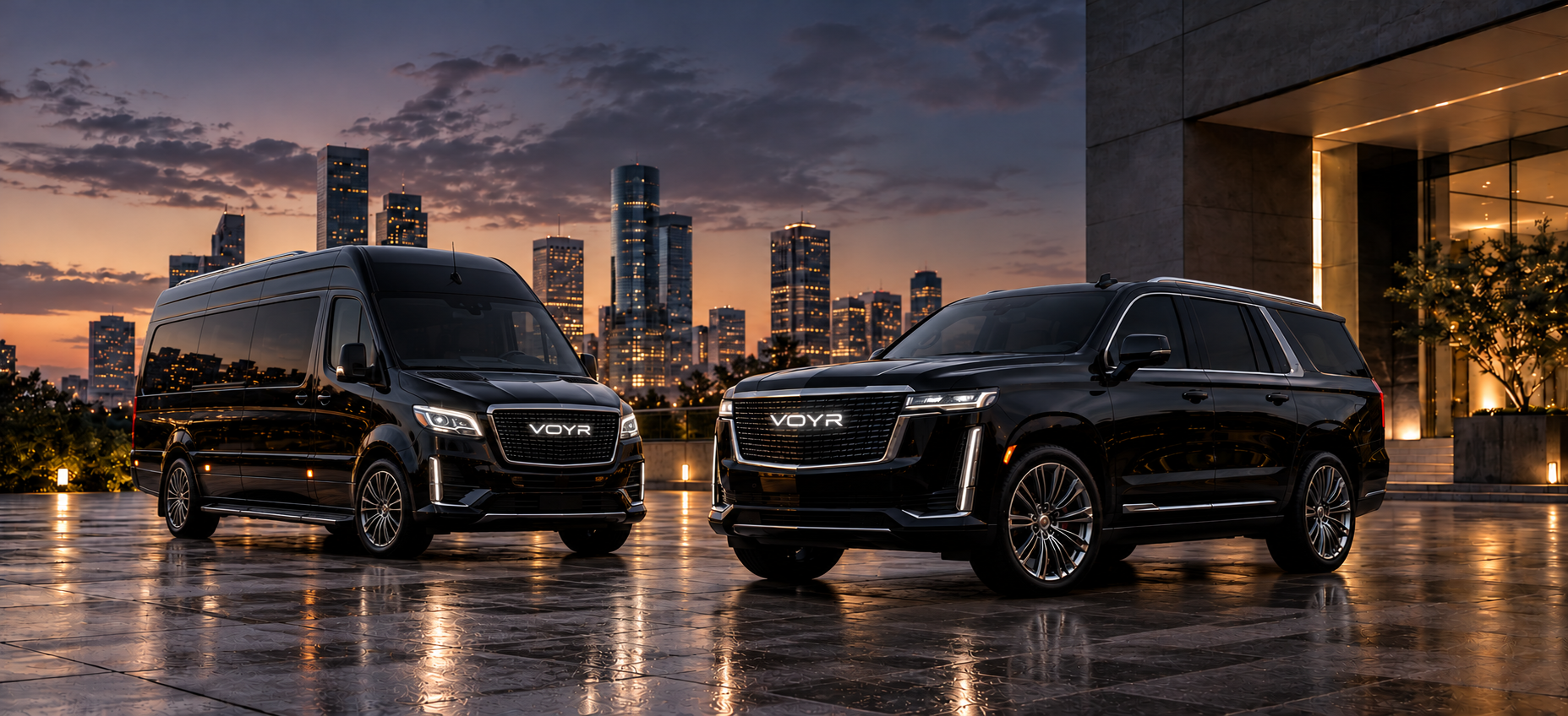 Black Sprinter passenger van and luxury SUV with illuminated VOYR grille emblems, against a city skyline at dusk